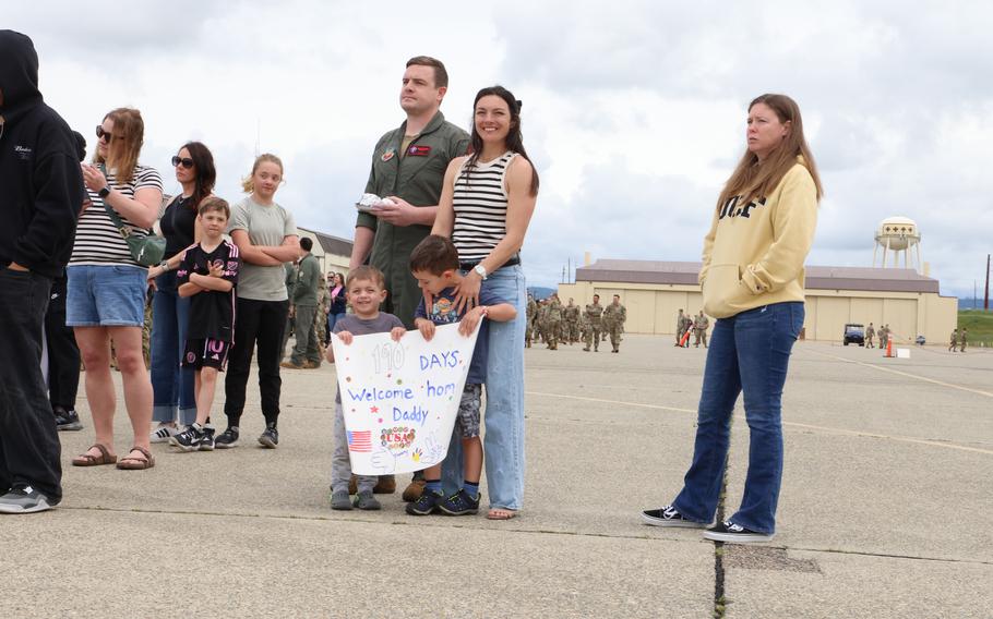 A family stands together with a poster