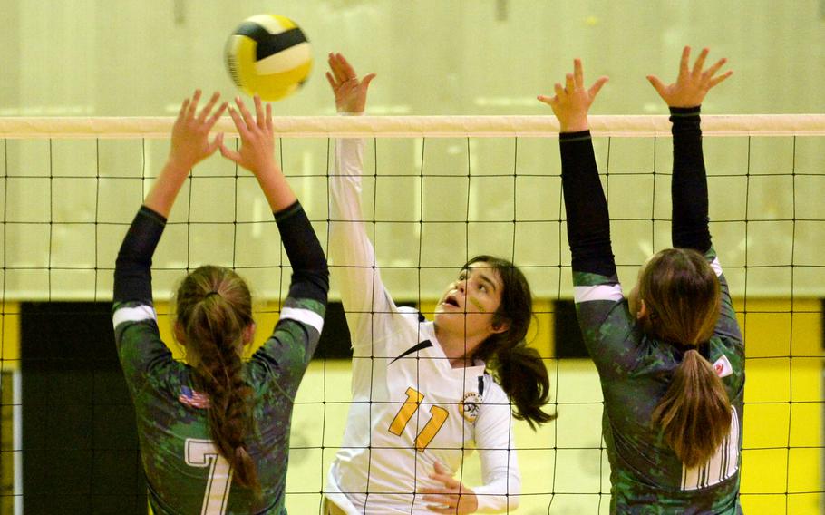 Kadena's Leighton Botes spikes against Kubasaki's Isabella Garza and Jackie Mitchell during Tuesday's Okinawa volleyball match. The Dragons won in four sets and won the season series 3-1.