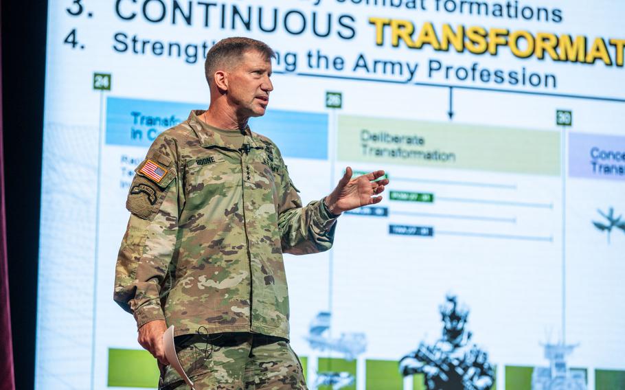 General David Hodne in fatigues standing, gesturing with his left hand and speaking.