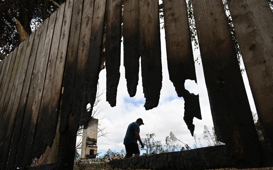 Mark Ross works on cutting burnt fence on his property that was destroyed by last week’s fire on Wednesday, Aug. 16, 2023, in Kula, Hawaii.