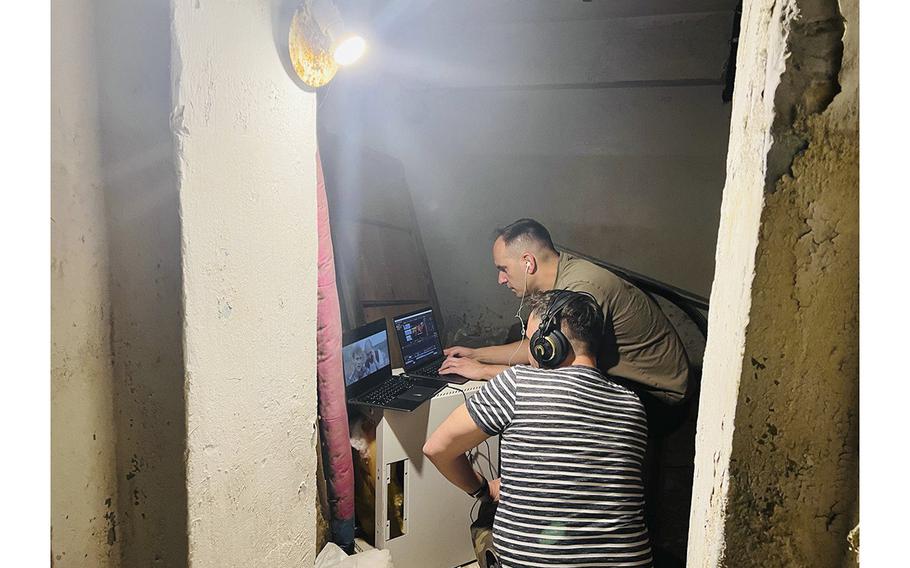 In a bomb shelter in Kyiv, Victor Geenchuk, foreground, and Igor Volkov watch footage of a comedy series they are wrapping in Ukraine.
