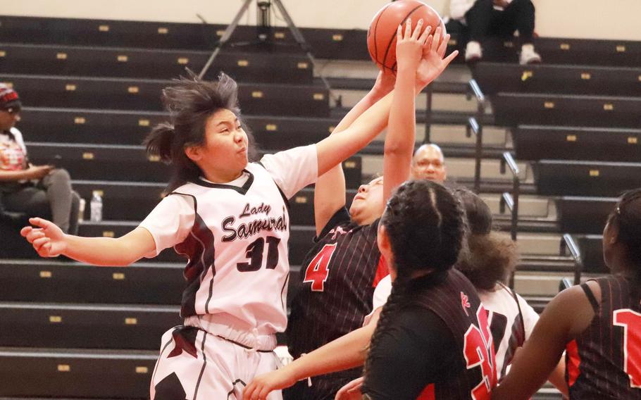 Matthew C. Perry's Veatriz Orozco and Nile C. Kinnick's Sashia Loo battle for the ball during Saturday's DODEA-Japan girls basketball game. The Red Devils won 38-19.