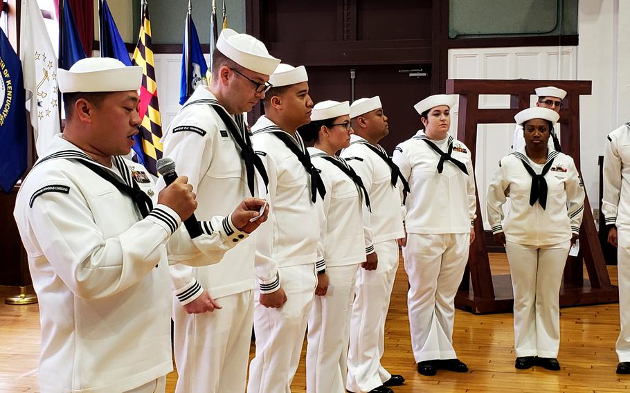 A volunteer reads the names of sailors who died over the past year during a Bells Across America ceremony at Yokosuka Naval Base, Japan, Thursday, Sept. 22, 2022.