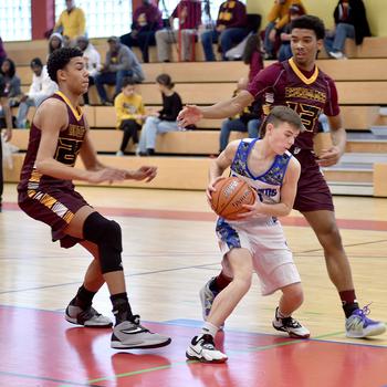 Brussels' William Stewart picks up the ball while Baumholder defenders Damian Jung, left, and Caleb Pigge prepare to trap during a game on Saturday afternoon in the Hall of Champions Fitness Center in Baumholder, Germany. The Buccaneers defeated the Brigands, 47-21.