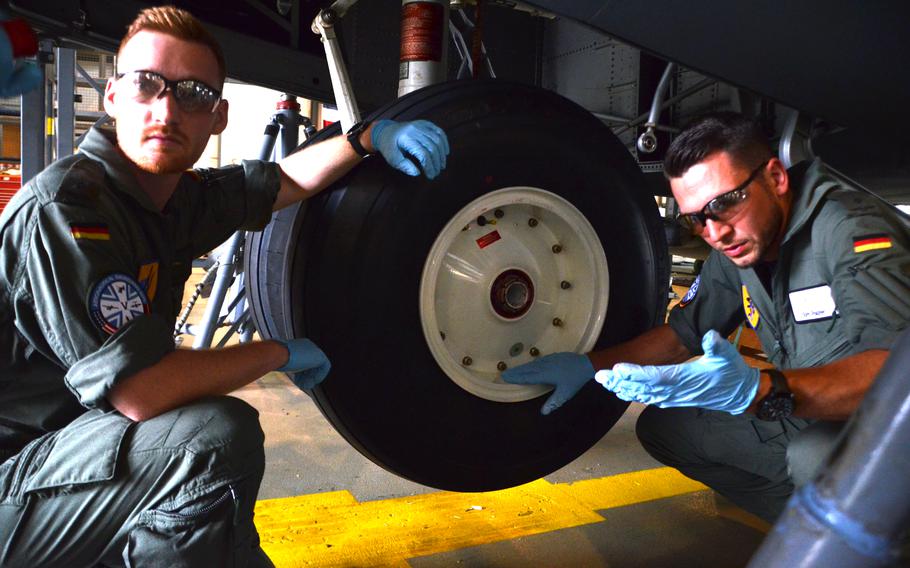 German military academy cadets Tim Herbst, left, and Tom Palzer listen to instructions from U.S. maintainers at Ramstein Air Base before removing the wheels of a C-130J to check the bearings on July 15, 2021. The future Luftwaffe pilots were among seven cadets majoring in aeronautical engineering at the University of the Armed Forces in Munich who did their required practical training at the U.S. air base. 