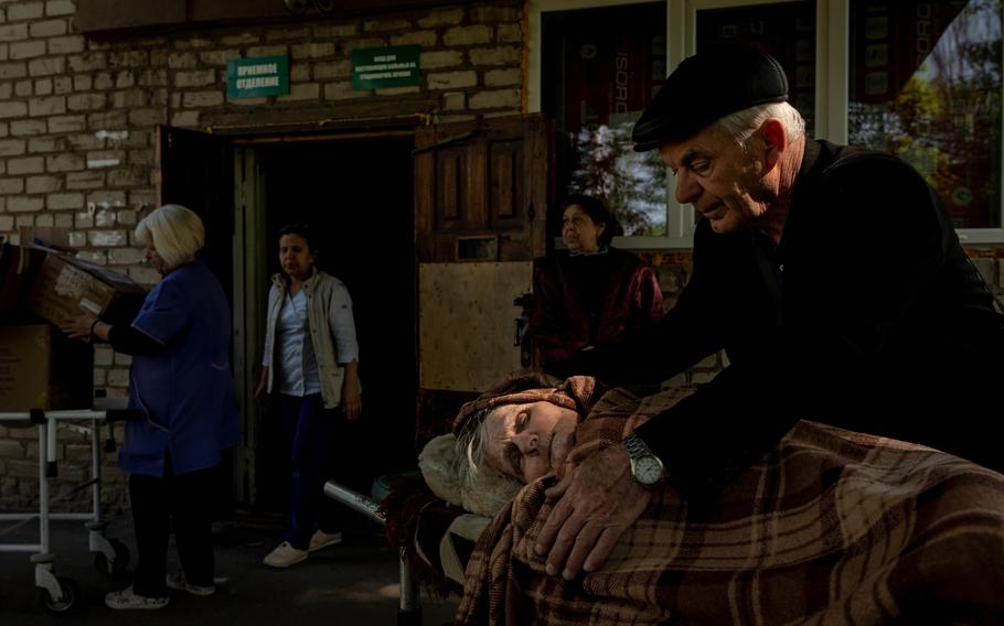 Volodymyr Yutin, 70, comforts his mother, Katerina, 94, at a hospital in Donbas after they were evacuated from the town of Lyman.