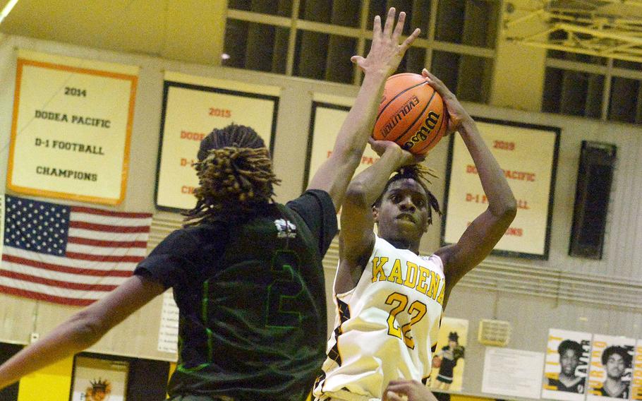 Kadena's Jayden Allen shoots over Kubasaki's Carlos Cadet during Friday's Okinawa boys basketball game. The Panthers won 49-44, completing a four-game season-series sweep of the Dragons.