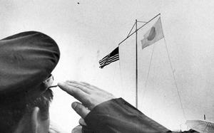 A Japanese soldier salutes as U.S. and Japanese flags fly side-by-side on Okinawa, May 15, 1972, the day Okinawa reverted to Japan, ending 27 years of American rule.
