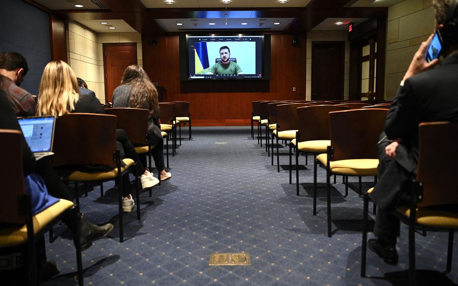 Reporters watch as Ukraine President Volodymyr Zelenskyy delivers a video address to the U.S. Congress in the Congressional Auditorium at the U.S. Capitol in Washington, D.C., on March 16, 2022. 