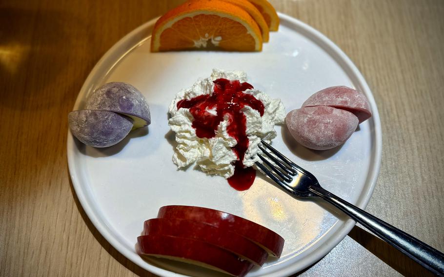 A mochi mix desert served with fruit and whipped cream.