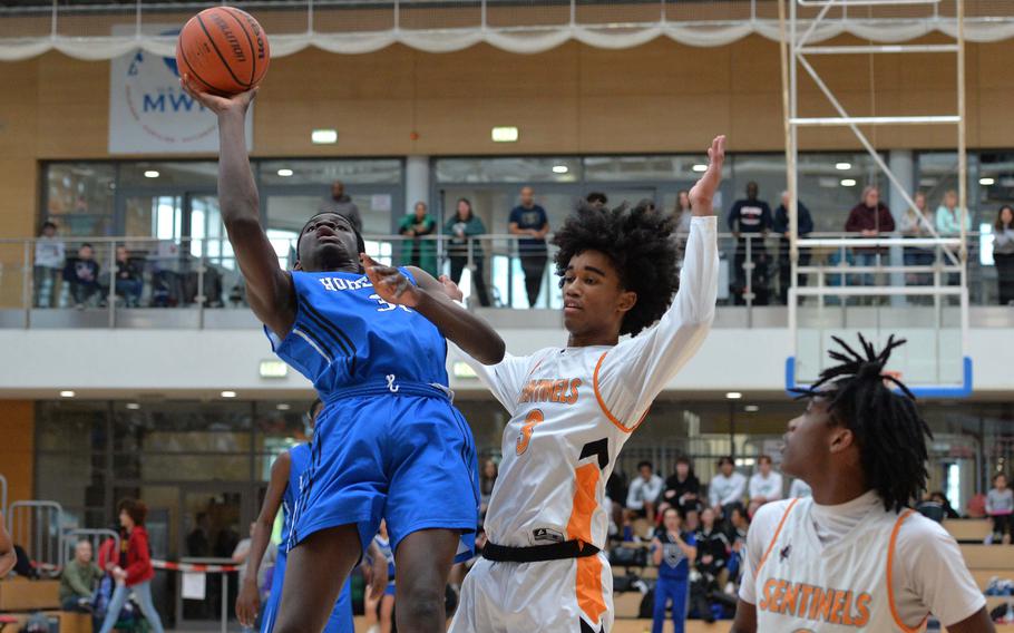 Hohenfels’ Joel Idowu gets an off balance shot against Spangdahlem’s Robert Leggett  in the boys Division III final at the DODEA-Europe basketball championships in Wiesbaden, Germany, Feb. 17, 2024. The Sentinels beat the Cougars in an exciting game 65-63 to take the DIII crown.