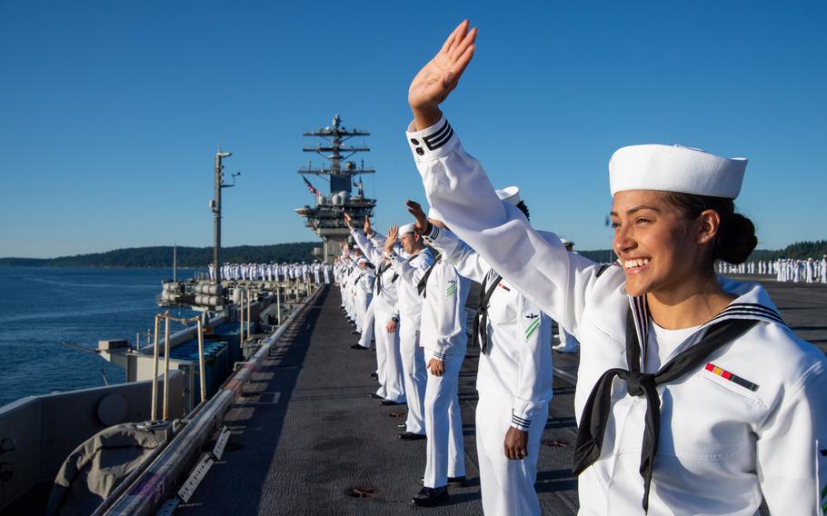 U.S. Navy Sailors wave to onlookers as they man the rails on the flight deck of the aircraft carrier USS Nimitz (CVN 68) on its return to its homeport in Bremerton, Wash., Sunday, July 2, 2023. Nimitz returned following a seven-month deployment to U.S. 3rd and 7th Fleet areas of operations.