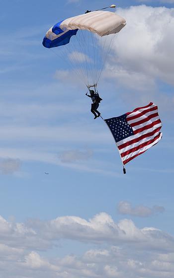 A man gliding with a parachute with the American flag.