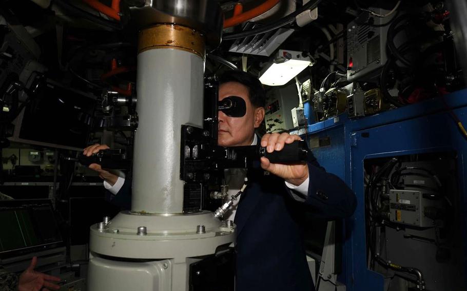 South Korean President Yoon Suk Yeol looks through the periscope of the ballistic missile submarine USS Kentucky at Naval Fleet Headquarters in Busan, South Korea, Wednesday, July 19, 2023.