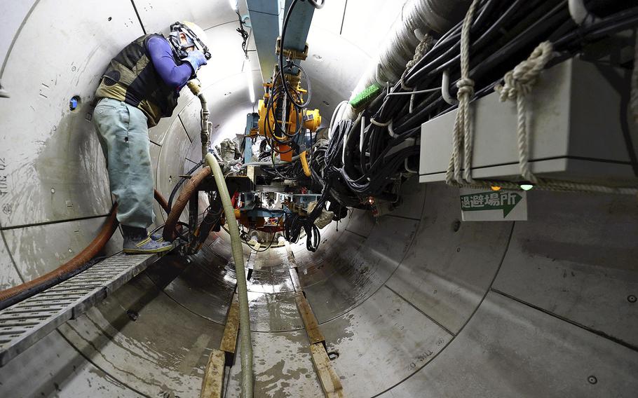 A construction worker on Tuesday, Sept. 6, 2022, handles a machine being used to build a tunnel at Fukushima No. 1 nuclear power plant to discharge treated water into the ocean.