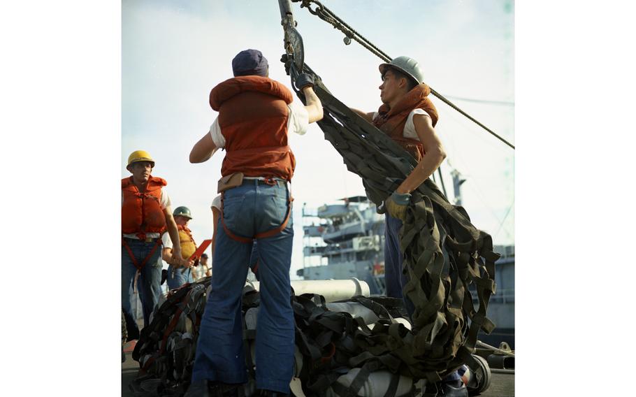Ammunition is hoisted aboard the USS Buchanan destroyer during rearming operations. The tanker USS Tappahannock can be seen in the background. 