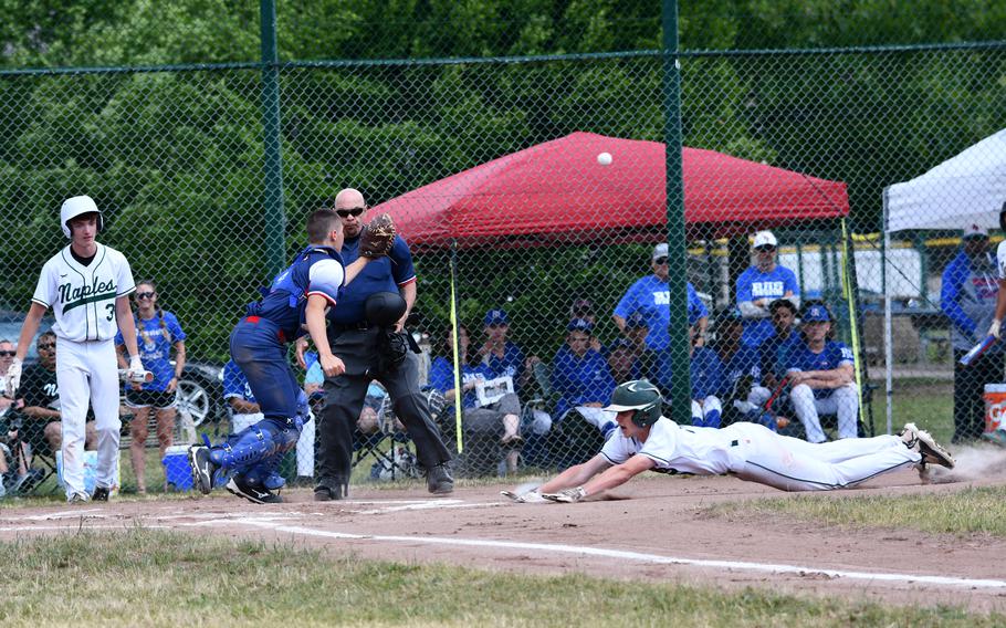 Naples Wildcats Patrick Fraim dives headfirst into home plate after a wild throw at third base during the 2022 DODEA-Europe Division II/III baseball championship game against the Aviano Saints.