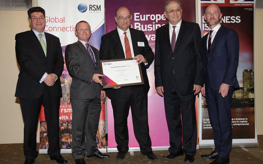 Nikos Bogonikolos, center, stands with officials of the European Business Awards in January 2015. The U.S. Justice Department is accusing Bogonikolos, a defense contractor and the president of the Aratos Group, of selling sensitive Western technology to Russia. 