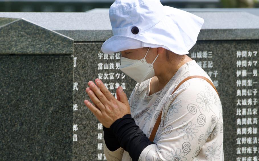 A woman prays for loved ones lost in the Battle of Okinawa during the Irei no Hi ceremony at Peace Memorial Park in Itoman, Okinawa, Friday, June 23, 2023.