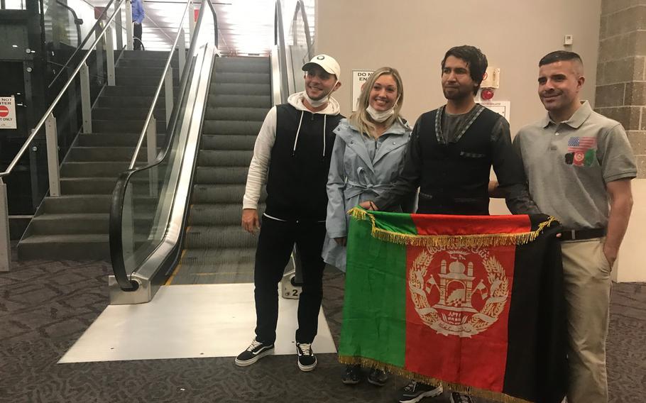 Amin Faqiry and supporters pose with the traditional flag of Afghanistan at T.F. Green International Airport.