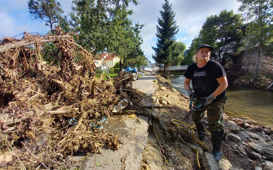 Stephanie Anderons, a German married to a retired American airman, helped clean up parts of the river bank on July 31, 2021, in Rittersdorf, Germany. Western Germany saw some of its worst flooding in decades last month. 