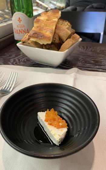 An amuse-bouche of ricotta cheese with diced red pepper and olive oil starts the meal during a recent visit to Roscioli in Rome.