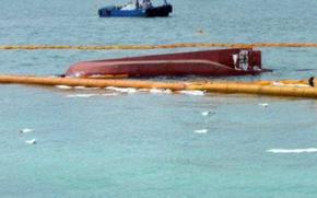 Debris from a capsized boat floats on the surface of water.