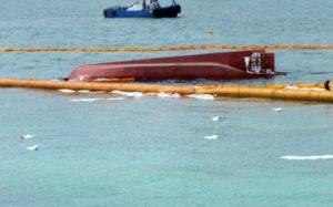 Debris from a capsized boat floats on the surface of water.
