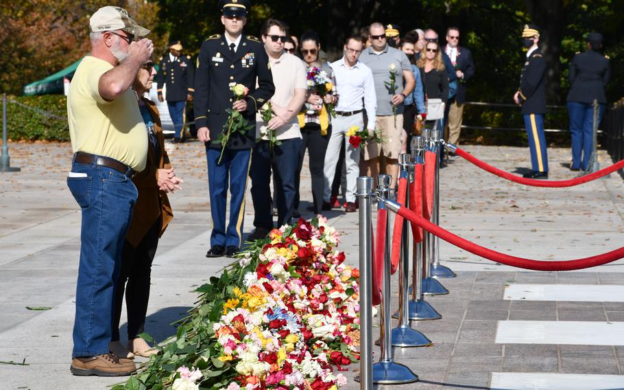 A visitor salutes the Tomb of the Unknown Soldier on Wednesday, Nov. 10, 2021, after laying a flower at its base. For the first time in recent history, Arlington National Cemetery allowed members of the public to approach the tomb. The event was held to commemorate the 100th anniversary of the site. 