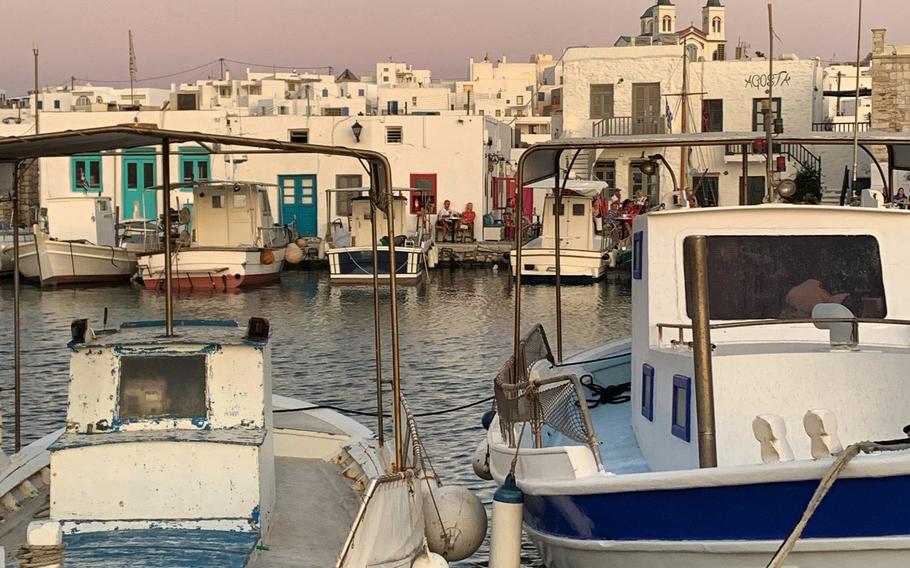 Fishing boats bob in Naousa's port during a September sunset. 