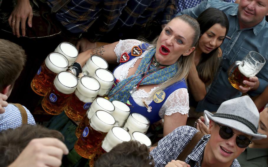 A waitress holds twelve glasses of beer during the opening of the 186th ‘Oktoberfest’ beer festival in Munich, Germany, on Sept. 21, 2019. 