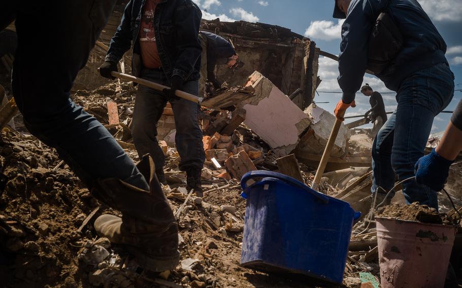 Volunteers working on clearing rubble from a damaged section of Kharkiv. 