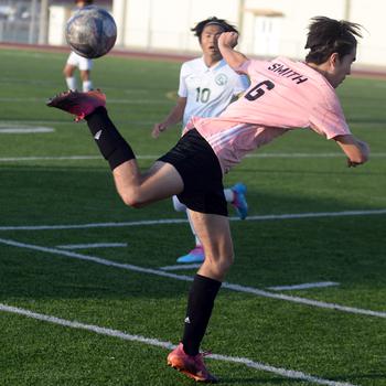 With his back to the ball, Kadena's Tyler Smith kicks against Kubasaki during Wednesday's DODEA-Okinawa boys soccer match. The teams battled to a 0-0 draw.