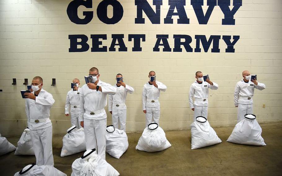 Incoming plebes read their Reef Points as they wait to move out.. The Naval Academy welcomed incoming freshman, or what they call plebes, during Induction Day, Wednesday, June 30, 2021, to begin their plebe summer.