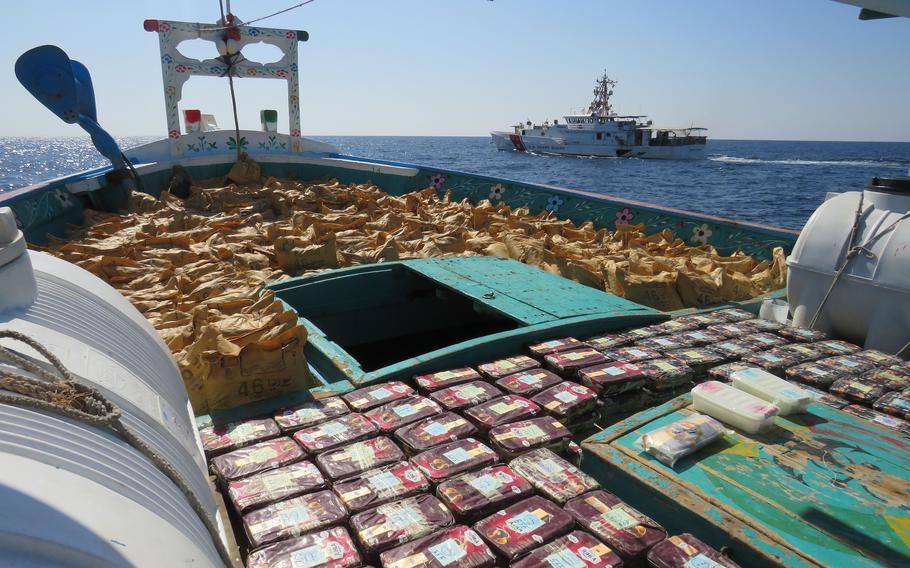 Drugs are laid out on the deck of a fishing boat in the Gulf of Oman on Jan. 30, 2023, after interdiction by U.S. Coast Guard cutter Emlen Tunnell, seen in the background.