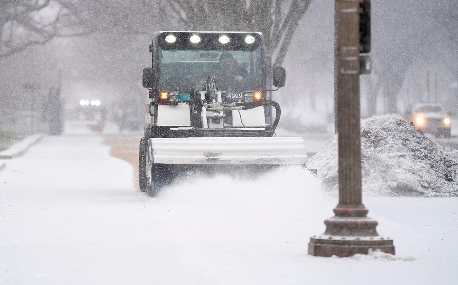 A snow sweeper clears sidewalks near the National Mall in Washington, DC, during a winter storm on Jan. 16, 2022. 