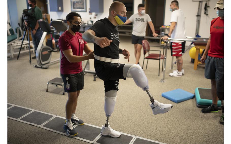 Joe Lopez, left, a physical therapy student at St. Catherine University in St. Paul, helped Daniel Sivakov, 21, of Mariupol, Ukraine, at the NovaCare Rehabilitation clinic in Crystal, Minn. Sivakov lost both legs in a Russian rocket attack. 