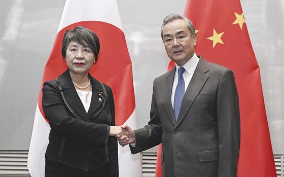 Japanese Foreign Minister Yoko Kamikawa, left, and her Chinese counterpart, Wang Yi, shake hands during their bilateral talk,  in South Korea's southern port city of Busan, ahead of Sunday's three-way talks Saturday, Nov. 25, 2023.