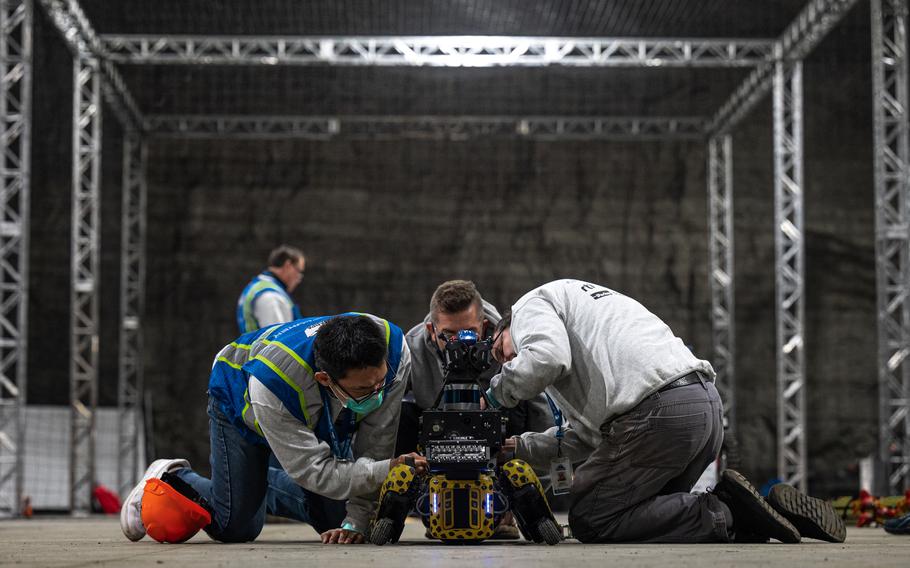 Members of the Explorer team, from Carnegie Mellon University, working on one of their robots in the staging area during the competition.