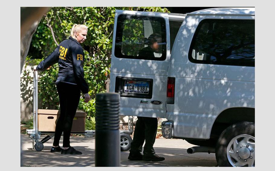 FBI agents load boxes into a van while the federal agents raid the Medoc Health Services company in Dallas on May 9, 2018.