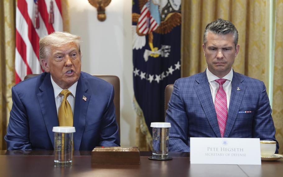 President Donald Trump and Defense Secretary Pete Hegseth seated in suits at a table.