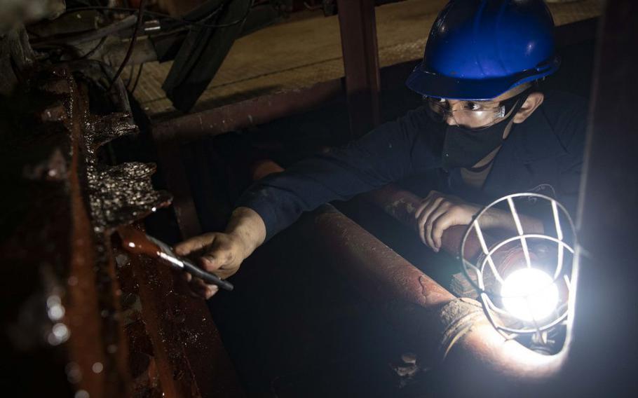 Fireman Apprentice Christian Leon paints the main machinery room foundation on USS Bataan while the ship is in the General Dynamics NASSCO shipyard for  maintenance.