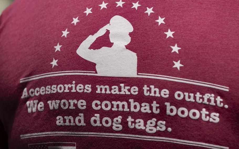 A pink shirt that says “Accessories make the outfit. We wore combat boots and dog tags.”