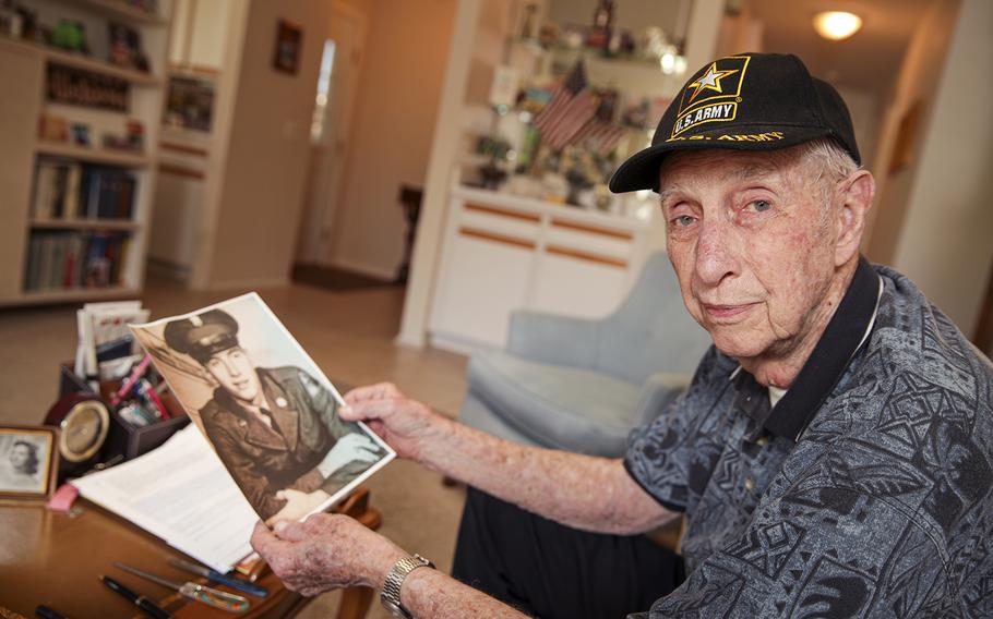 Army veteran Ed McNew, 89, has been among those pushing the Irvine City Council to build a veterans cemetery at the site of the long-closed El Toro Marine Base, part of the Great Park in Irvine. McNew is holding a photo of himself as a 23-year-old soldier stationed in Japan. 