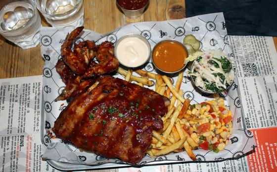 A smoked ribs and wing platter served with coleslaw, dips, fries and corn at Smoke Works in Cambridge, England. The barbecue restaurant offers an assortment of platters as well as great service.
