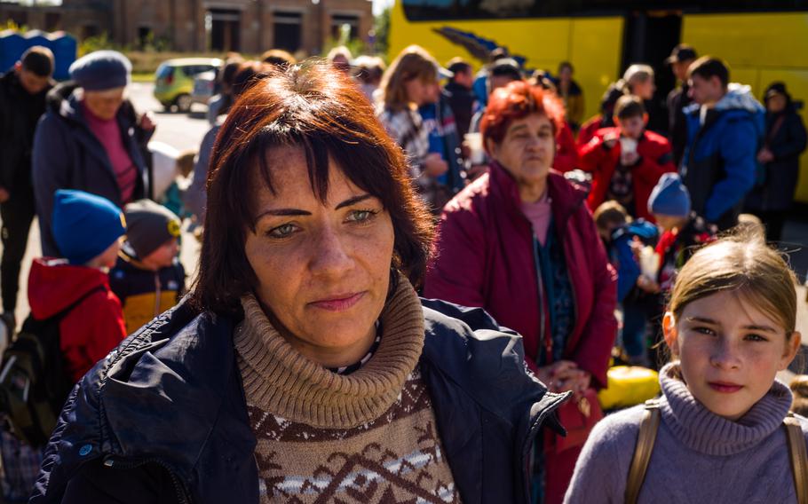 A woman and her daughter wait for buses leaving Zaporizhzhia on Wednesday.