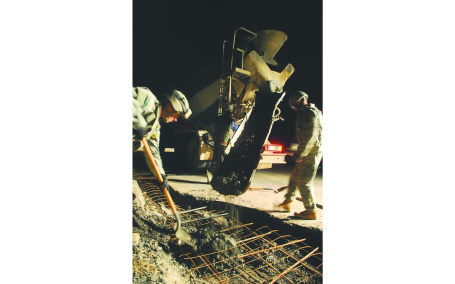 Soldiers with 1st Platoon, 60th Engineering Company, who are attached to the 19th Engineer Battalion, pour concrete into a roadside bomb crater. If left unrepaired, the craters provide hiding places for explosives and driving hazards for motor vehicles.