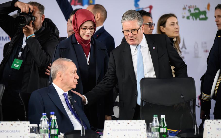 British Prime Minister Keir Starmer puts his hand on the shoulder of Turkish President Recep Erdogan.