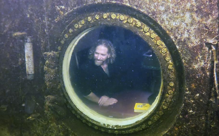 Diving explorer and medical researcher Dr. Joseph Dituri peers out of a large porthole, Saturday, May 13, 2023, at Jules’ Undersea Lodge positioned at the bottom of a 30-foot-deep lagoon in Key Largo, Fla. On Saturday, Dituri broke a record for the longest time living underwater at ambient pressure, his 74th day of a planned 100-day mission living submerged in the Florida Keys.