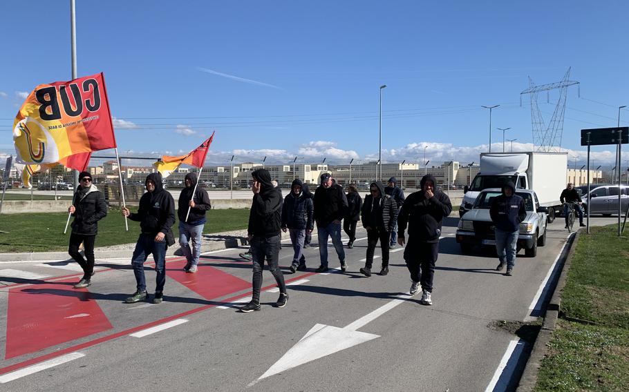 Maintenance workers wave flags and slow traffic outside Naval Support Activity Naples' Support Site location Feb. 21, 2024, to protest the base's landlord. They say the company, Mirabella, does not pay them on time. Mirabella officials say they've paid the employees in accordance with the terms of their contract.